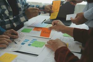 Close up ux developer and ui designer brainstorming about mobile app interface wireframe design on table with customer breif and color code at modern office.Creative digital development agency photo