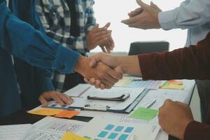 Close up ux developer and ui designer brainstorming about mobile app interface wireframe design on table with customer breif and color code at modern office.Creative digital development agency photo