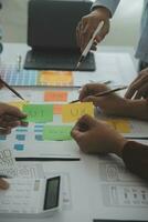 Close up ux developer and ui designer brainstorming about mobile app interface wireframe design on table with customer breif and color code at modern office.Creative digital development agency photo