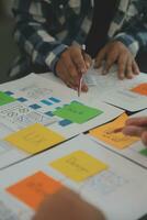 Close up ux developer and ui designer brainstorming about mobile app interface wireframe design on table with customer breif and color code at modern office.Creative digital development agency photo