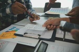 Close up ux developer and ui designer brainstorming about mobile app interface wireframe design on table with customer breif and color code at modern office.Creative digital development agency photo