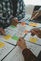 Close up ux developer and ui designer brainstorming about mobile app interface wireframe design on table with customer breif and color code at modern office.Creative digital development agency photo