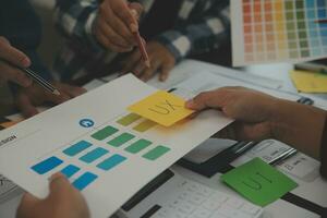 Close up ux developer and ui designer brainstorming about mobile app interface wireframe design on table with customer breif and color code at modern office.Creative digital development agency photo