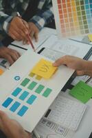 Close up ux developer and ui designer brainstorming about mobile app interface wireframe design on table with customer breif and color code at modern office.Creative digital development agency photo