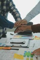 Close up ux developer and ui designer brainstorming about mobile app interface wireframe design on table with customer breif and color code at modern office.Creative digital development agency photo