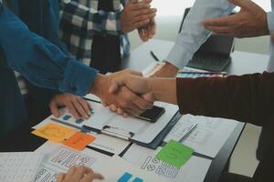 Close up ux developer and ui designer brainstorming about mobile app interface wireframe design on table with customer breif and color code at modern office.Creative digital development agency photo