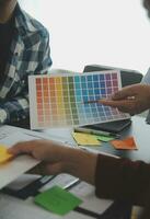 Close up ux developer and ui designer brainstorming about mobile app interface wireframe design on table with customer breif and color code at modern office.Creative digital development agency photo