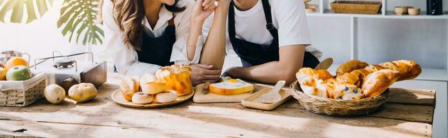 Happy young adult couple making breakfast and drinking coffee together in cozy home kitchen in morning at home. Preparing meal and smiling. Lifestyle, leisure and Love concept. photo