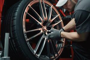 Close-up of a car mechanic changing a wheel with a wrench. Car mechanic repairing car wheel in auto repair shop. ai generated pro photo