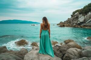 Beautiful woman in dress standing on rock with beautiful sea background.Generative Ai. photo