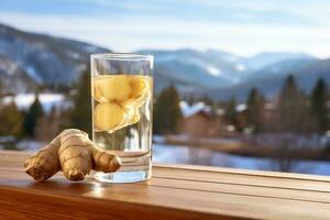 Ginger water in glass with ginger on wooden table background photo