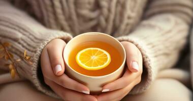 Woman holds in hand cup with orange tea photo