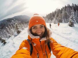 A woman wearing an orange jacket is selfieing on a snowy slope photo