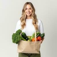 mujer con papel bolso con vegetales foto