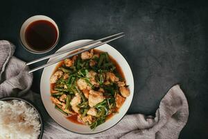 Top view,  Stir-fried pork and red hot curry paste with or long bean and Ingredients are oyster sauce, fish sauce, sugar, kaffir lime leaves in the dish Eat with cooked rice. Thai food photo