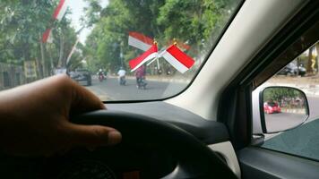 The Indonesian flag is mounted on the windshield of the car to welcome Indonesia's independence day photo