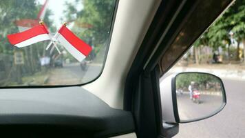 The Indonesian flag is mounted on the windshield of the car to welcome Indonesia's independence day photo