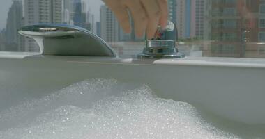 Woman pouring water into the bathtub with foam video