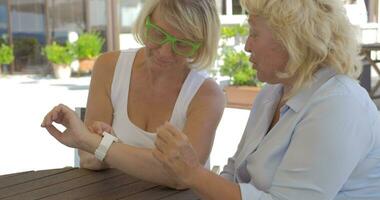 In city of Perea, Greece two adult women learning how working smart watch video