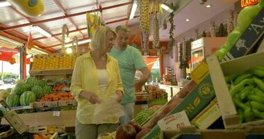 senior mensen nemen perziken in fruit winkel video