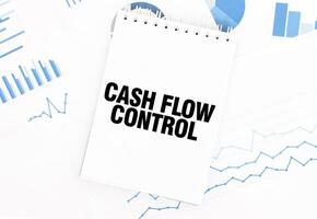 White notepad with text CASH FLOW CONTROL on the financial documentation. Finance and business concept photo