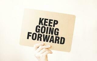 Closeup Business man hand holding show blank paper sheet mock up . Text KEEP GOING FORWARD photo