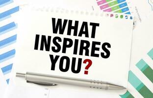 WHAT INSPIRES YOU on white paper sheet on charts photo