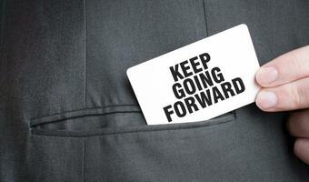 Card with KEEP GOING FORWARD text in pocket of businessman suit. Investment and decisions business concept. photo