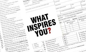 WHAT INSPIRES YOU on white sticker with documents photo