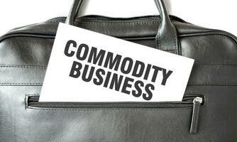 Text COMMODITY BUSINESS writing on white paper sheet in the black business bag. Business concept photo