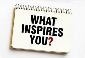 WHAT INSPIRES YOU on notepad with white background photo