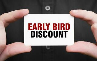 Businessman holding a card with text EARLY BIRD DISCOUNT , business concept photo