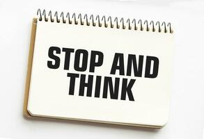 STOP AND THINK on notepad with white background photo