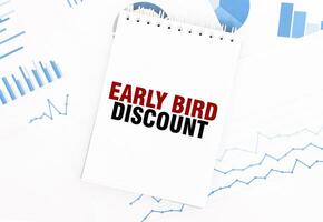 White notepad with text EARLY BIRD DISCOUNT on the financial documentation. Finance and business concept photo