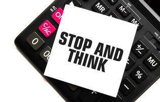 STOP AND THINK on white sticker with calculator on white sticker with calculator photo