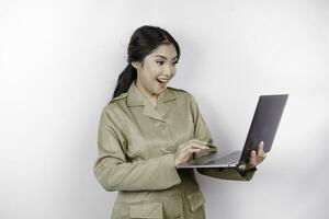 contento gobierno trabajador mujer participación su ordenador portátil mientras sonriente. pns vistiendo caqui uniforme. foto