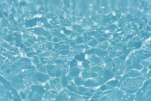 Blue water with ripples on the surface. Defocus blurred transparent blue colored clear calm water surface texture with splashes and bubbles. Water waves with shining pattern texture background. photo