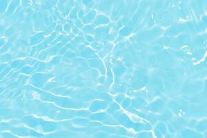 Blue water with ripples on the surface. Defocus blurred transparent blue colored clear calm water surface texture with splashes and bubbles. Water waves with shining pattern texture background. photo