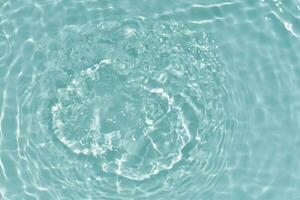 Blue water with ripples on the surface. Defocus blurred transparent blue colored clear calm water surface texture with splashes and bubbles. Water waves with shining pattern texture background. photo