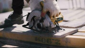 worker at a construction site saws a wooden beam with an electric saw video