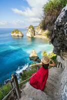 joven mujer viajero relajante y disfrutando el hermosa ver a diamante playa en nusa penida isla, bali foto