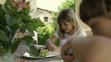 caucásico niña de 7 7 años antiguo tiene brócoli como un almuerzo. video