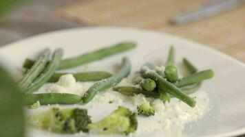 en tallrik med grön bönor och broccoli på den video