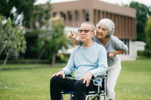 Asian senior couple having a good time. They laughing and smiling while sitting outdoor at the park. Lovely senior couple photo