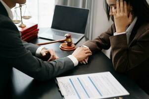 Business people compassionately holding hands and discussing contract papers with laptop and tabletat office photo