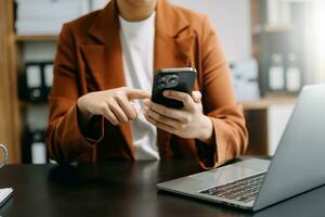 business documents on office table with smart phone and digital tablet and graph financial and woman working at office photo