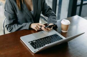 Mano de mujer de negocios usando teléfonos inteligentes, pagos con tableta y sosteniendo tarjetas de crédito, compras en línea, canal omnidireccional, computadora con teclado de acoplamiento de tableta digital en la oficina a la luz del sol foto