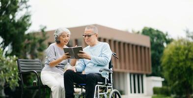 Asian senior couple having a good time. They laughing and smiling while sitting outdoor at the park. Lovely senior couple photo