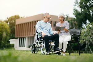 Asian senior couple having a good time. They laughing and smiling while sitting outdoor at the park. Lovely senior couple photo