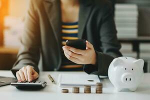 contador comercial que trabaja en el escritorio usando teléfono móvil y calculadora para calcular el concepto de presupuesto financiero y contable a la luz de la mañana foto